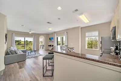 a kitchen and living room of a home with a bar at Modern Pet-Friendly - 2BR Condo - 6 mins from Disney in Orlando