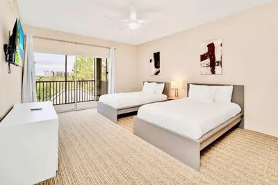 a bedroom with two beds and a balcony at Condo with Pet-Friendly- Sauna & Pool in Orlando