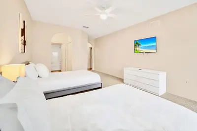 a white bedroom with two beds and a dresser at Condo with Pet-Friendly- Sauna & Pool in Orlando