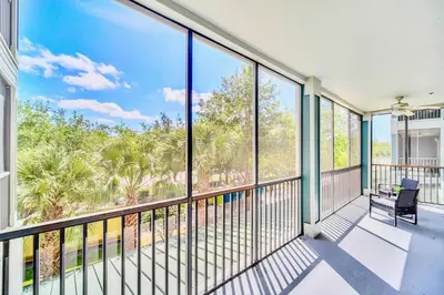 a balcony with a chair and large windows at Stylish 2BR Retreat w Pool Sauna in Orlando