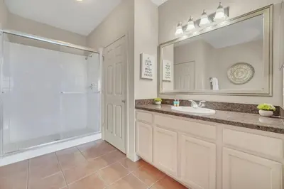 a bathroom with a sink and a shower and a mirror at Upstay - Condo - Hot Tub & Pool in Orlando