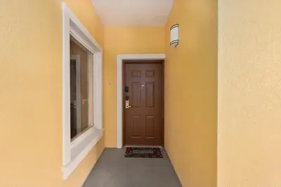 a hallway with a brown door and a window at Fabulous Condo at World Quest Resort Disney area in Orlando