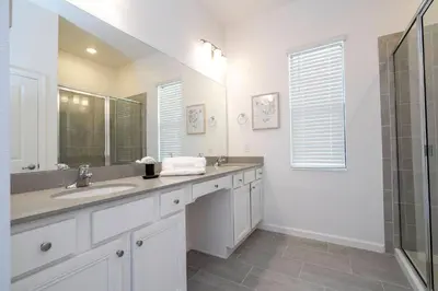 a white bathroom with two sinks and a shower at NEW Paradiso Grande Disney Themed Cinema5827 in Orlando