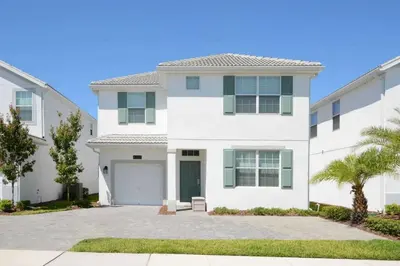 a white house with a driveway at Casa 6 Quartos | Piscina Privativa | 10min Disney! in Kissimmee