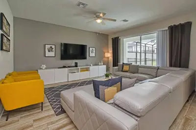 a living room with a couch and a tv at Casa 6 Quartos | Piscina Privativa | 10min Disney! in Kissimmee