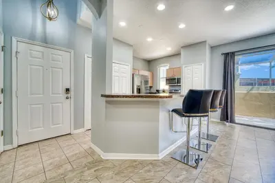 a kitchen with a counter and a bar with chairs at Stylish Townhome Close to Disney Parks in Kissimmee