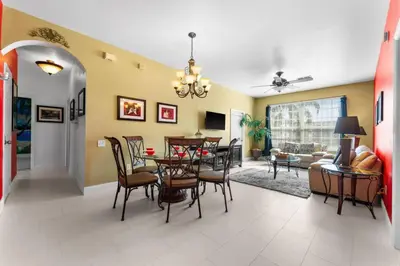 a dining room and living room with a table and chairs at Windsor Palms Mickey Themed Condo, Pool, By Disney in Kissimmee