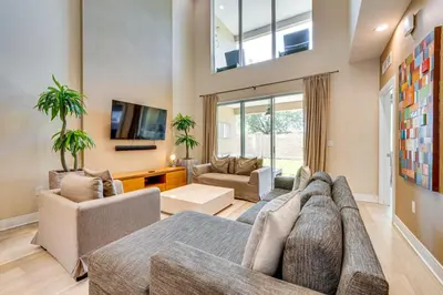 a living room with a couch and a tv at Less Than 2 Mi to WDW Attractions Luxe Family Getaway! in Orlando