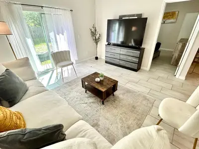 a living room with a couch and a tv at Entire House in Orlando close to All Parks in Orlando
