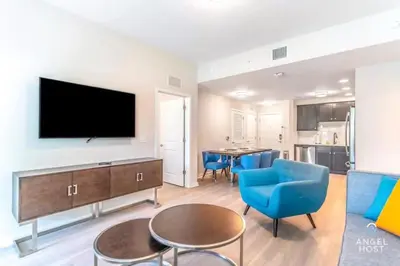 a living room with a flat screen tv and blue chairs at Vista Cay Resort in Orlando