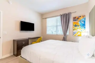 a bedroom with a white bed and a television at Vista Cay Resort in Orlando