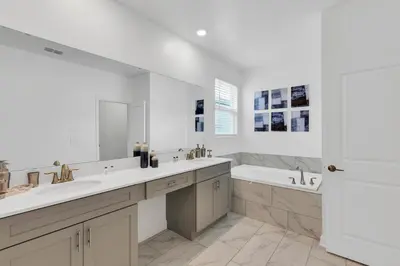 a white bathroom with two sinks and a tub at Dream Vacation Home – Private Pool, Themed Rooms & Resort Access – ChampionsGate! in Kissimmee