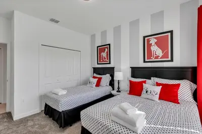 two beds in a room with red and white pillows at Dream Vacation Home – Private Pool, Themed Rooms & Resort Access – ChampionsGate! in Kissimmee