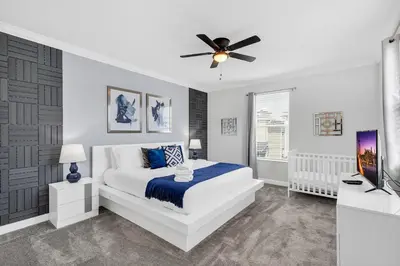 a white bedroom with a bed and a ceiling fan at Dream Vacation Home – Private Pool, Themed Rooms & Resort Access – ChampionsGate! in Kissimmee