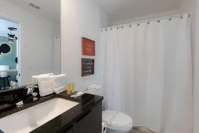 a bathroom with a white shower curtain and a sink at Amazing 03 Bedrooms 03 Baths Sleeps 08 in Kissimmee