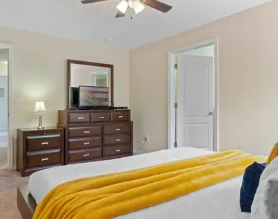a bedroom with a bed and a dresser and a mirror at Amazing 05 Bedrooms 4 Bathrooms Sleeps 14 in Kissimmee