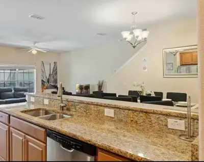 a kitchen with a sink and a living room at Amazing 05 Bedrooms 4 Bathrooms Sleeps 14 in Kissimmee