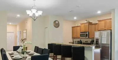 a kitchen and dining room with a table and chairs at Amazing 05 Bedrooms 4 Bathrooms Sleeps 14 in Kissimmee