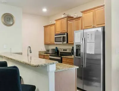 a kitchen with stainless steel appliances and wooden cabinets at Amazing 05 Bedrooms 4 Bathrooms Sleeps 14 in Kissimmee