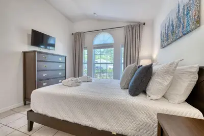 a bedroom with a bed with a dresser and a window at Private Pool Getaway Near Theme Parks in Kissimmee