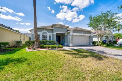 a house with a palm tree in a yard at Private Pool Getaway Near Theme Parks in Kissimmee