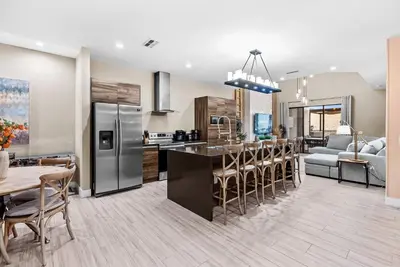a kitchen and living room with a table and chairs at Home Luxury 4 BedsPrivate Hot Tub Close Disney in Orlando
