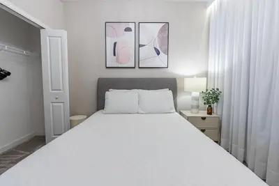 a bedroom with a white bed and two pictures on the wall at Brand New 5 Bedrooms4 Baths At Storey Lake in Kissimmee