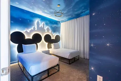 a bedroom with two beds and a disney castle mural at Brand New 5 Bedrooms4 Baths At Storey Lake in Kissimmee