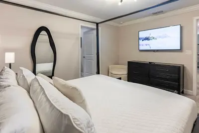 a bedroom with a bed and a flat screen tv at Brand New 5 Bedrooms4 Baths At Storey Lake in Kissimmee