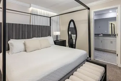 a bedroom with a large bed and a mirror at Brand New 5 Bedrooms4 Baths At Storey Lake in Kissimmee