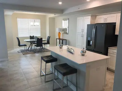 a kitchen with a large island with a refrigerator at Aqua Vista Storey Lake in Kissimmee