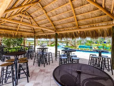 an outdoor patio with tables and chairs and a pool at Aqua Vista Gated Resort Style Community in Kissimmee