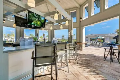 a bar with chairs and a flat screen tv at Aqua Vista Gated Resort Style Community in Kissimmee
