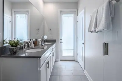 a white bathroom with a sink and a mirror at Brand New 5 Bedrooms5Baths At Storey Lake in Kissimmee