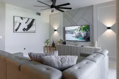 a living room with a couch and a flat screen tv at NEW Cozy 2 Bedrooms2Baths At Storey Lake in Kissimmee
