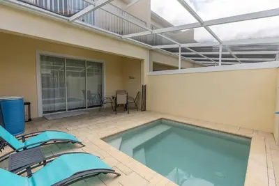 a swimming pool in a house with two chairs at Amazing 3 Bedrooms with Private Pool- Close to Disney in Orlando