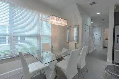 a dining room with a glass table and white chairs at Amazing 3 Bedrooms with Private Pool- Close to Disney in Orlando