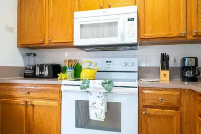a kitchen with a white stove top oven with a microwave at Charming Vacation Home 9 miles From Disney 1065 in Kissimmee