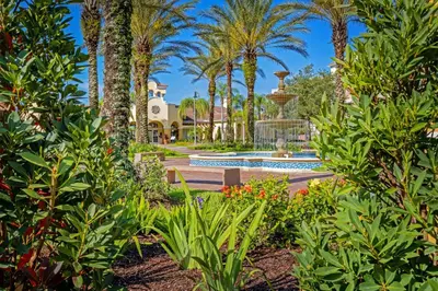 a garden with a fountain and palm trees at Epic Universe New Beautiful Condo, Vista Cay, Orlando - 3011 in Orlando