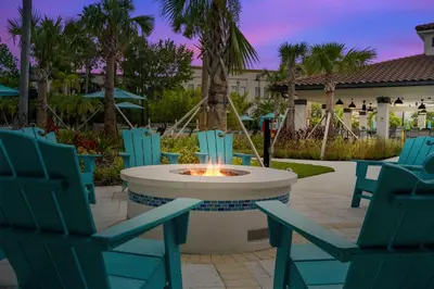 a group of chairs and a fire pit in a patio at Epic Universe Vista Cay Deluxe Condo, Near the Parks! - 3006 in Orlando