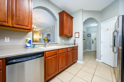 a kitchen with wooden cabinets and a dishwasher at New - Lakeview Vacation Condo - 3027 in Orlando