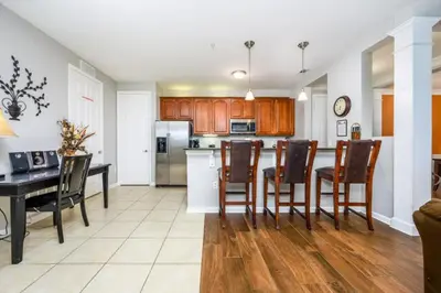 a kitchen and dining room with a table and chairs at Epic Universe NEW Beautiful Lakeview Condo Near the Parks - 1026 in Orlando