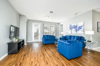 a living room with blue couches and a television at Epic Universe Family Fun Vista Cay Lakeview Condo - 1021 in Orlando