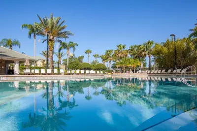 a large swimming pool with palm trees in the background at Epic Universe New Listing Beautiful Townhome, Vista Cay - 4019 in Orlando