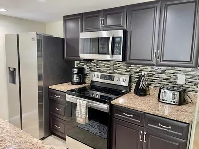 a kitchen with a stove and a refrigerator at Grand Laguna 3BR Penthouse Near Disney Parks in Kissimmee