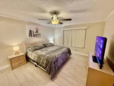 a bedroom with a bed and a flat screen tv at Grand Laguna 3BR Penthouse Near Disney Parks in Kissimmee