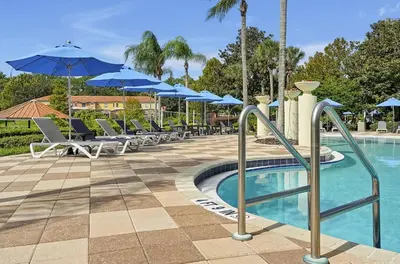 a pool with chairs and umbrellas at a resort at Encantada Resort 10 minutes to Disney w/ Pool in Kissimmee