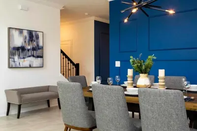 a dining room with blue walls and a table and chairs at Casa 5Q c/ Piscina e Temas da Disney in Kissimmee