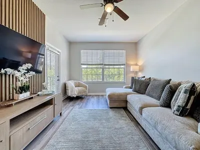 a living room with a couch and a flat screen tv at Beautiful Three bed condo, Minutes from Disney condo in Kissimmee