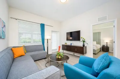 a living room with a couch and chairs and a tv at New Modern Vista Cay Reserve Condo - 5006 in Orlando